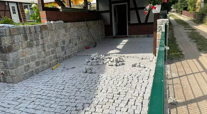Ein Weg zu einem Hauseingang wird frisch gepflastert