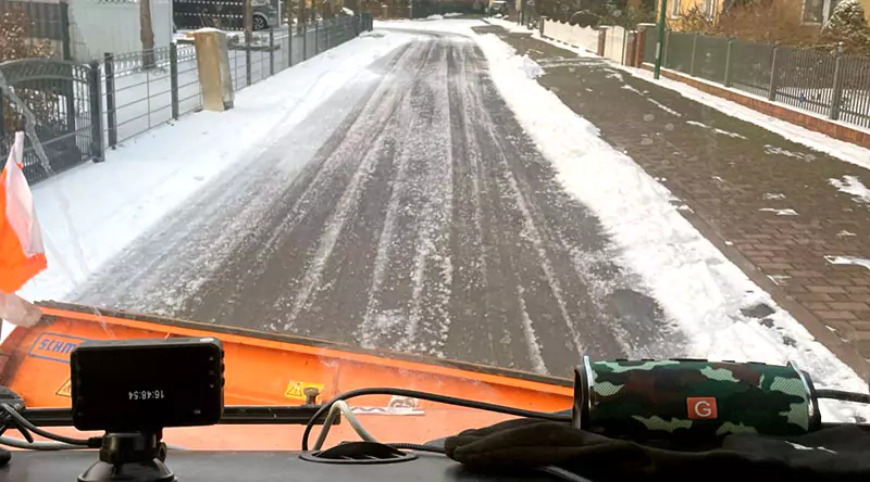 Ein Schneepflug räumt eine verschneite Straße